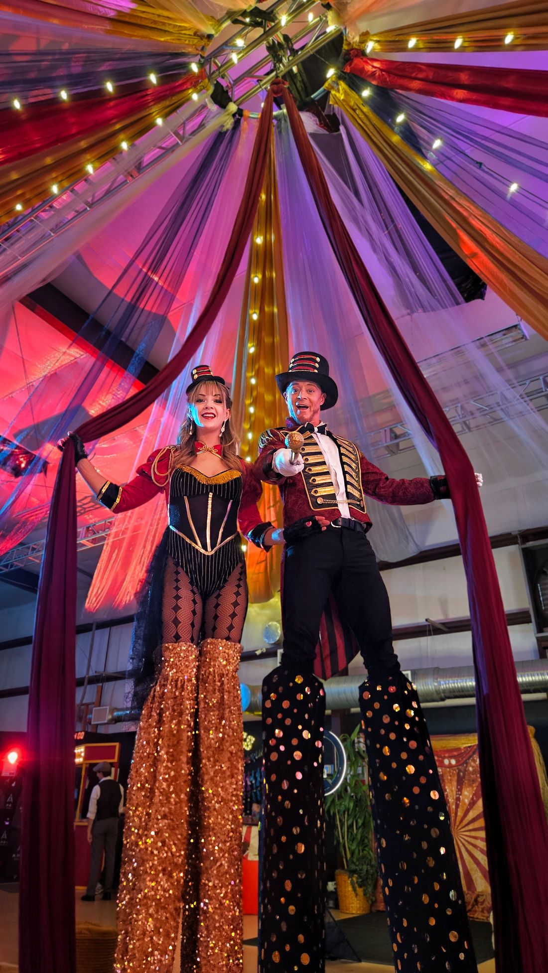 Ringmaster stiltwalkers towering over guests