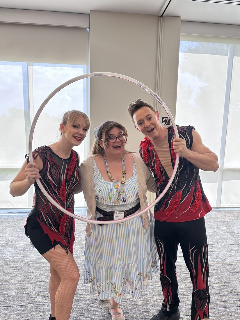 A smiling woman posing inside a hula hoop with Rocco and Nova